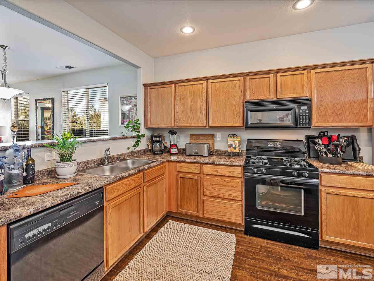 2289 Rio Lobo Lane Reno, NV 89521 - Photo 4 of 17 a kitchen with stainless steel appliances granite countertop a stove a sink and a microwave