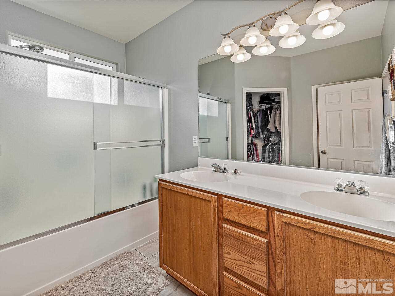 2289 Rio Lobo Lane Reno, NV 89521 - Photo 10 of 17 a bathroom with a granite countertop sink a large mirror and a shower