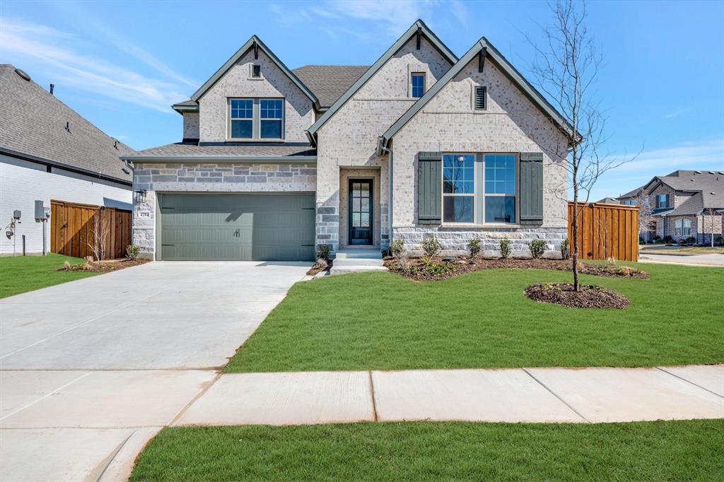 View of front of property with concrete driveway, a garage, and brick siding