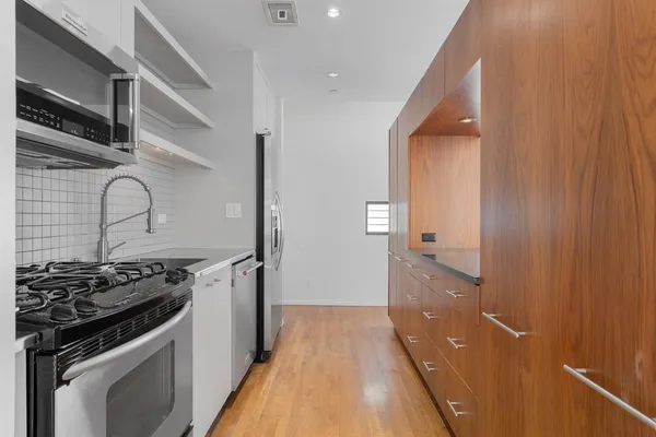 a kitchen with granite countertop a refrigerator and a sink