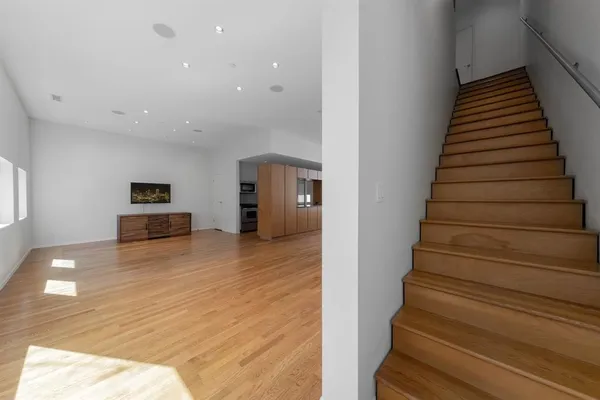a view of hallway with stairs and wooden floor