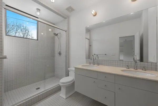 a bathroom with a sink shower and a mirror