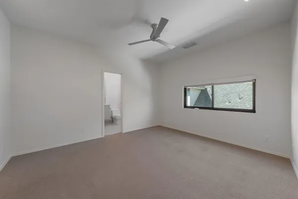an empty room with a ceiling fan and a window