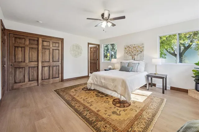 a bed sitting in a spacious bedroom next to a window