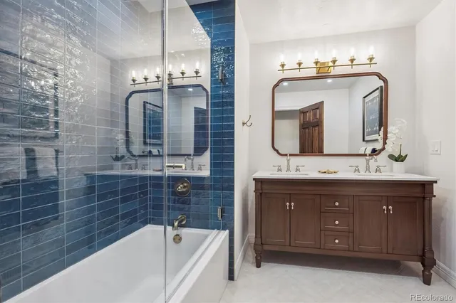a bathroom with a double vanity sink mirror and bathtub