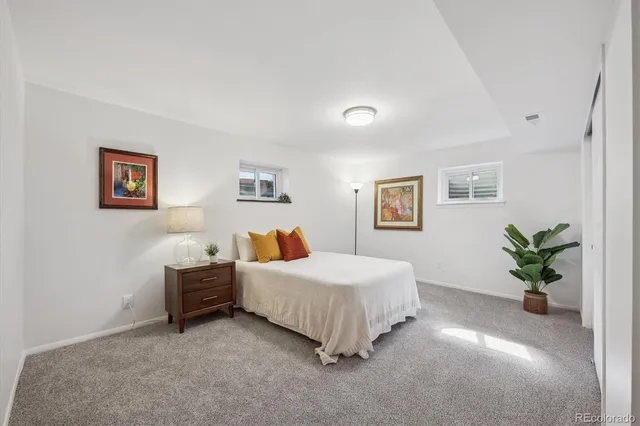 a spacious bedroom with a bed and a painting on the wall