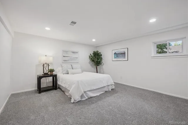 a spacious bedroom with a bed and a painting