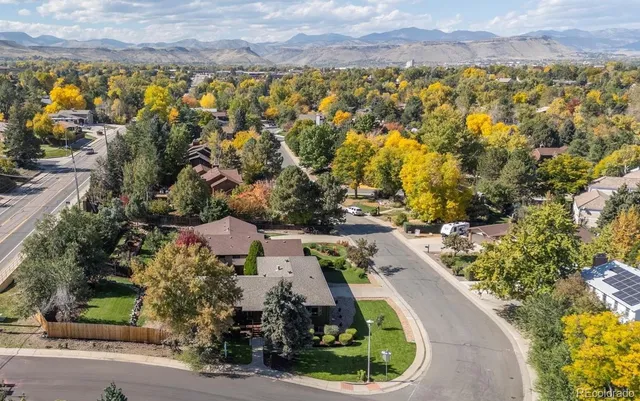 an aerial view of residential houses with outdoor space and trees