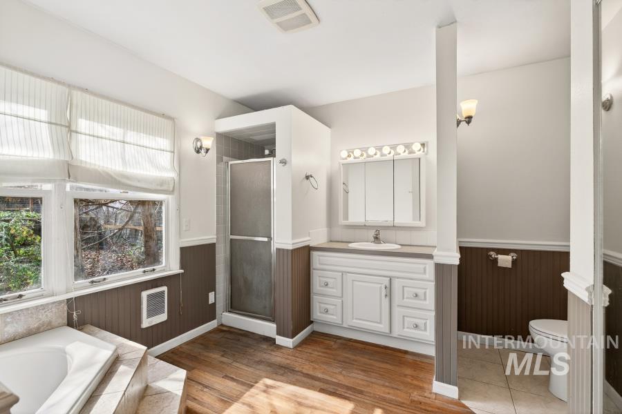 515 East D Street Moscow, ID 83843 - Photo 10 of 29 Full bathroom featuring vanity, a wainscoted wall, a stall shower, a garden tub, and heating unit