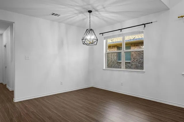 a view of a room with wooden floor fan and windows