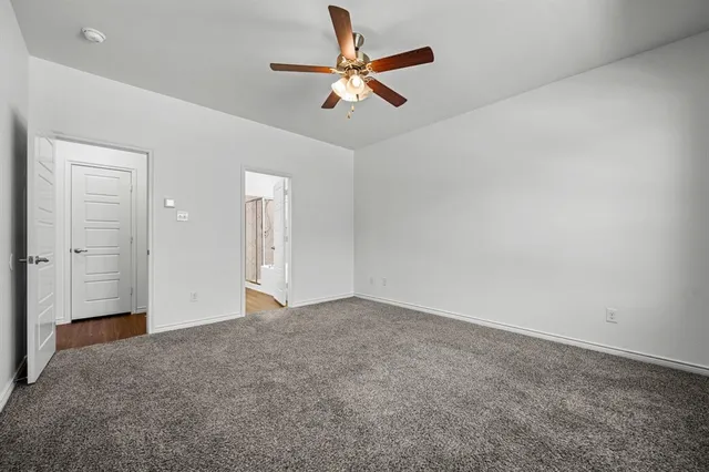 an empty room with closet and fan