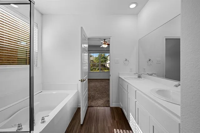 a bathroom with a bathtub sink and mirror