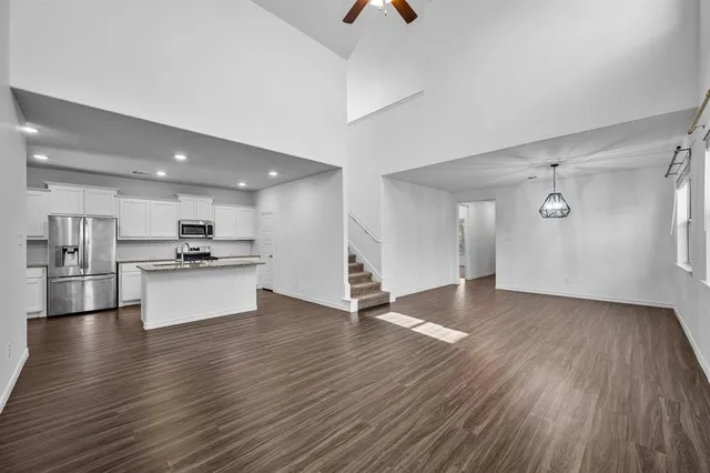 a view of kitchen with cabinets stainless steel appliances and wooden floor