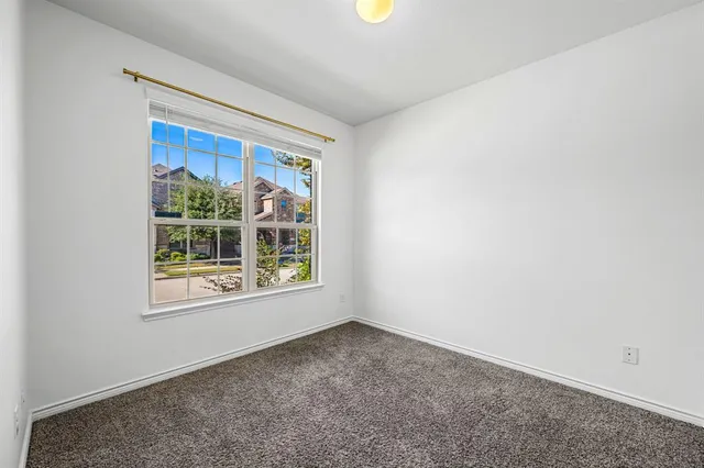 an empty room with ceiling fan and window