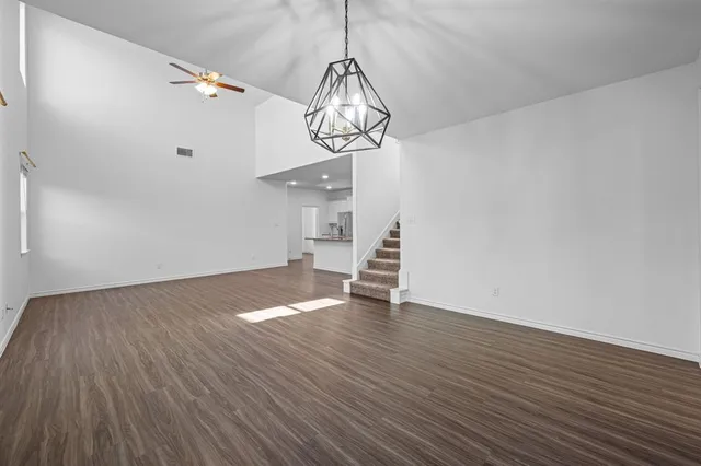 a view of empty room with wooden floor and window