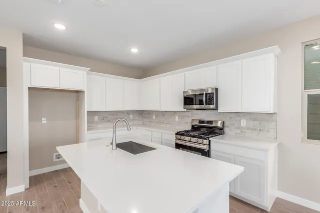 a kitchen with sink a microwave and cabinets