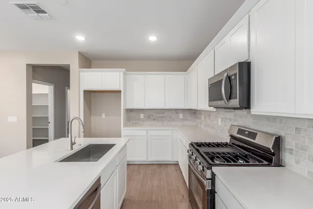 a kitchen with granite countertop a sink stove and cabinets
