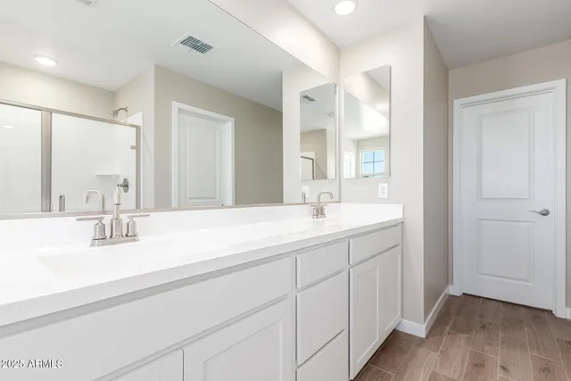 a bathroom with double vanity sinks and a mirror