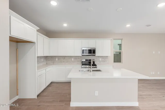 a kitchen with stainless steel appliances a sink stove and cabinets