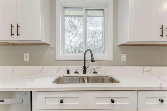 a kitchen with granite countertop a sink stainless steel appliances and cabinets