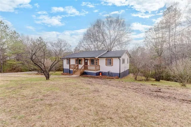 a stone house with a yard and a wooden fence
