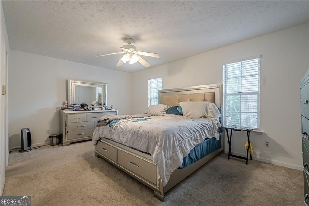 3403 Spring Harbor Lane Doraville, GA 30340 - Photo 16 of 27 a spacious bedroom with a bed and a ceiling fan