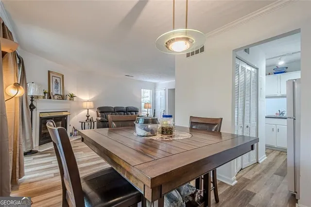 a view of a dining room with furniture a fireplace and wooden floor