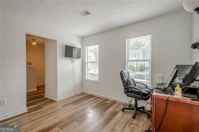 a view of a workspace with furniture and a window