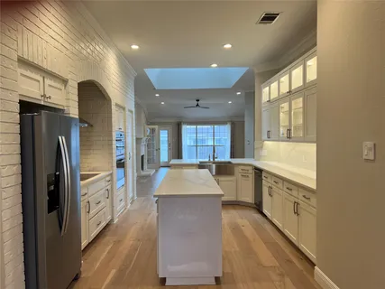 a large kitchen with a large window and stainless steel appliances