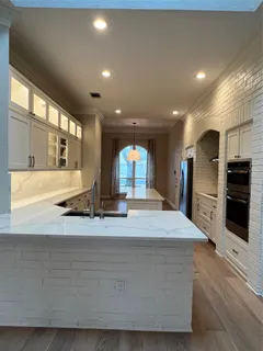 a large kitchen with kitchen island a sink stainless steel appliances and cabinets