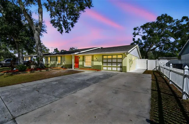 a view of a house with a yard and potted plants