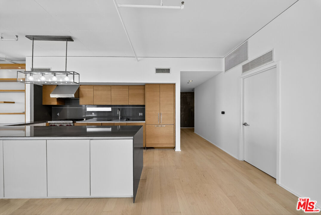 1100 South Hope Street, Unit 1501 Los Angeles, CA 90015 - Photo 41 of 63 a kitchen with stainless steel appliances granite countertop a stove and a sink