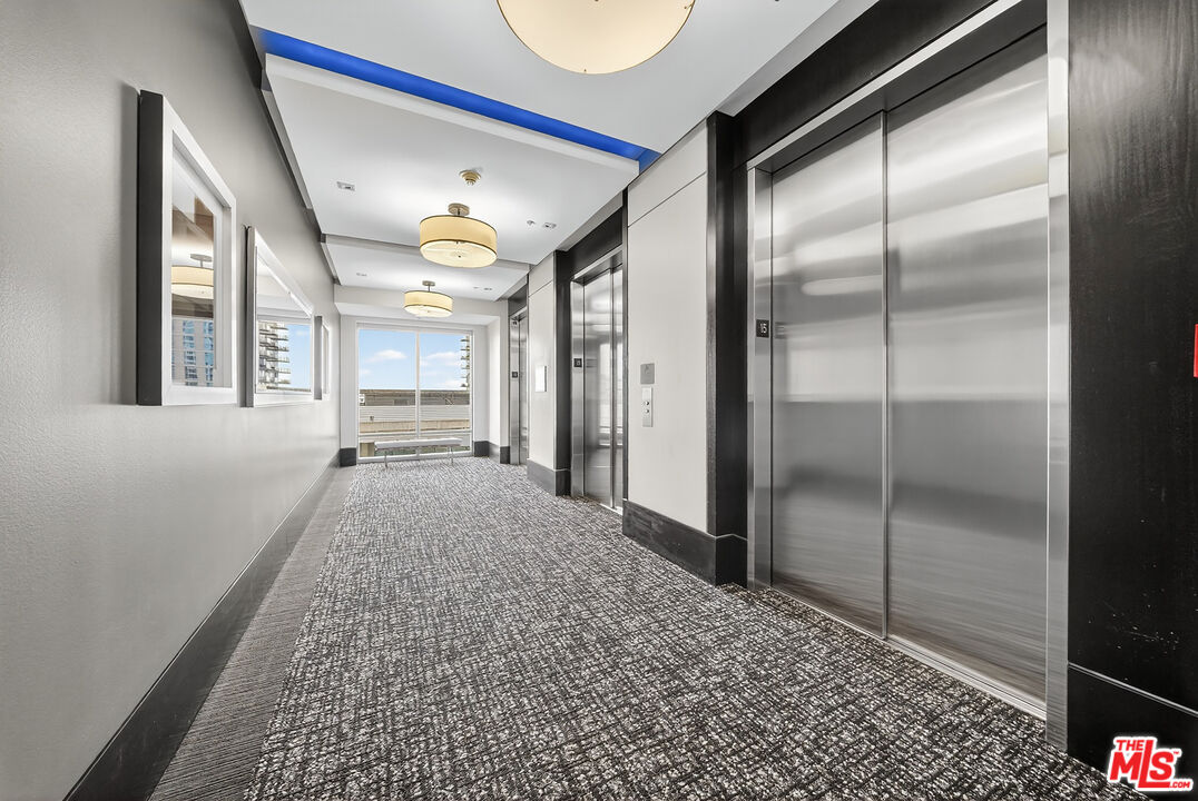 1100 South Hope Street, Unit 1501 Los Angeles, CA 90015 - Photo 43 of 63 a view of hallway with a large window and chandelier