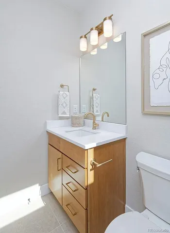 a bathroom with a sink vanity and a toilet