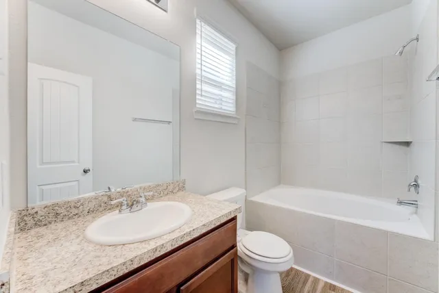 a bathroom with a granite countertop sink toilet and shower