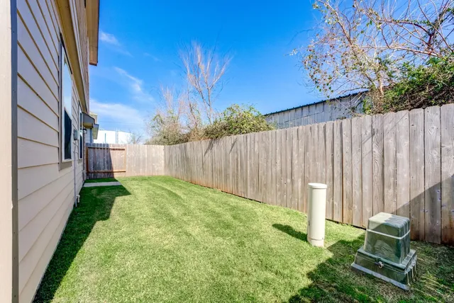 a view of backyard with potted plants and wooden fence
