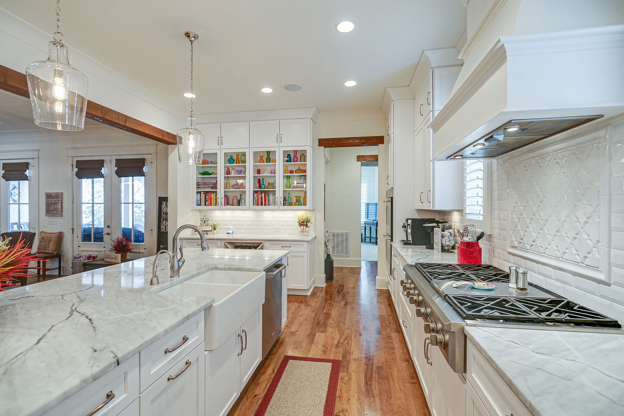 8448 Heirloom Boulevard College Grove, TN 37046 - Photo 14 of 41 a large kitchen with stainless steel appliances a stove a sink dishwasher and a dining table with wooden floor