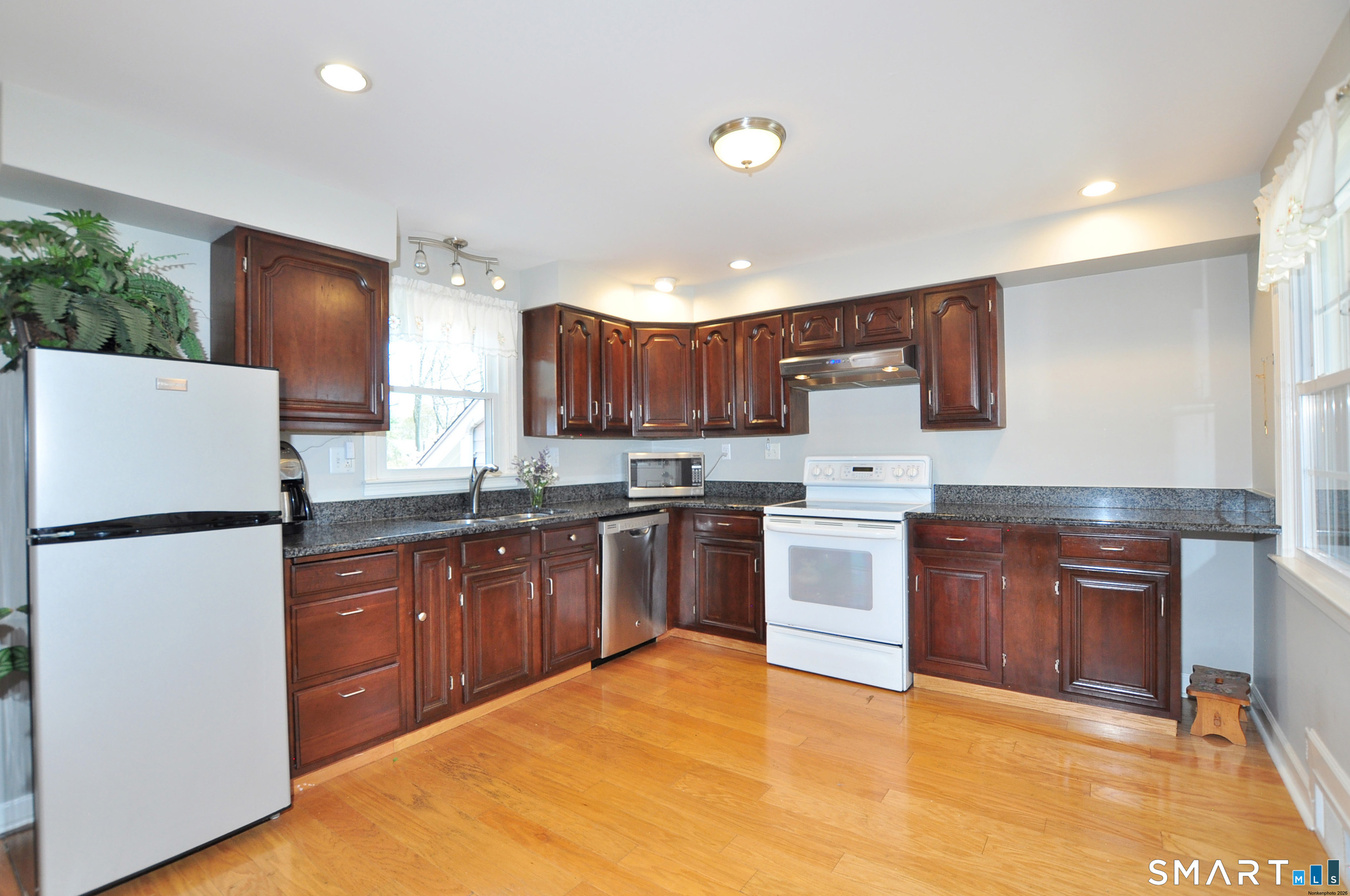 36 Pilgrim Drive Windsor, CT 06095 - Photo 7 of 33 a kitchen with wooden cabinets and white appliances