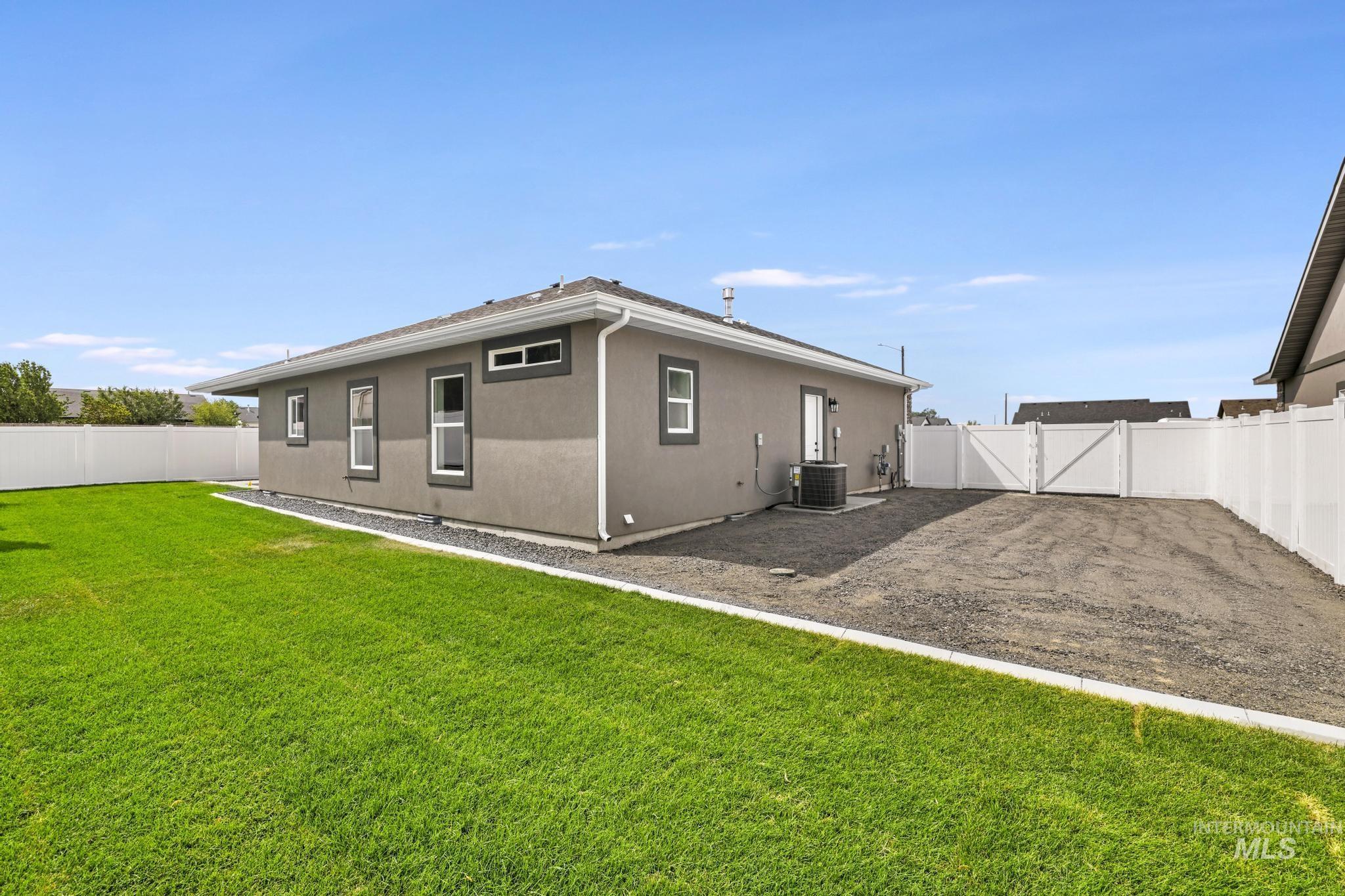 1414 Haizlee Way Twin Falls, ID 83301 - Photo 22 of 26 Back of property with a fenced backyard, stucco siding, and a gate