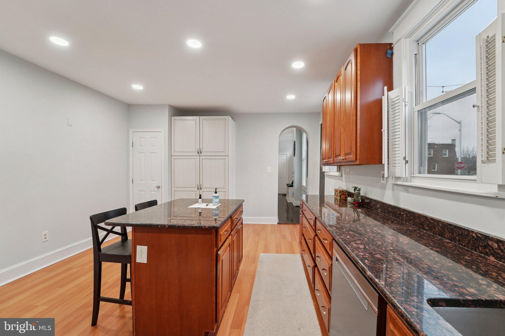 3929 Hudson Street Baltimore, MD 21224 - Photo 15 of 48 a large kitchen with kitchen island a large counter top space a sink stainless steel appliances and cabinets