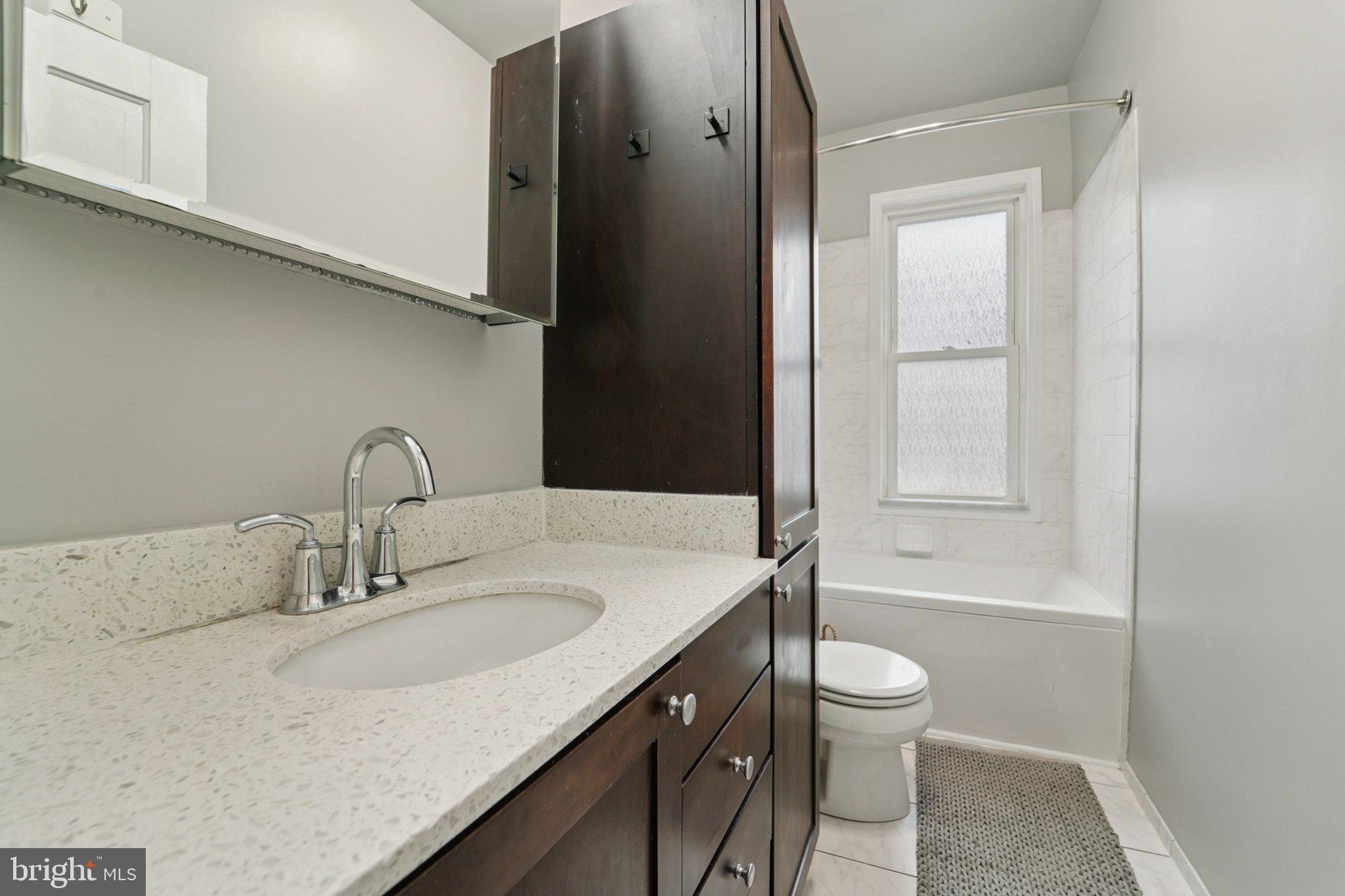 3929 Hudson Street Baltimore, MD 21224 - Photo 20 of 48 a bathroom with a granite countertop sink toilet and shower