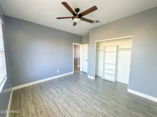 a spacious bathroom with a granite countertop sink a toilet a mirror and shower
