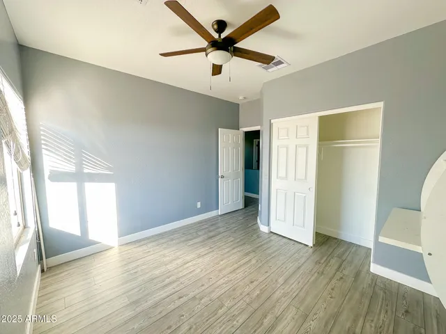 a view of a livingroom with wooden floor and a ceiling fan