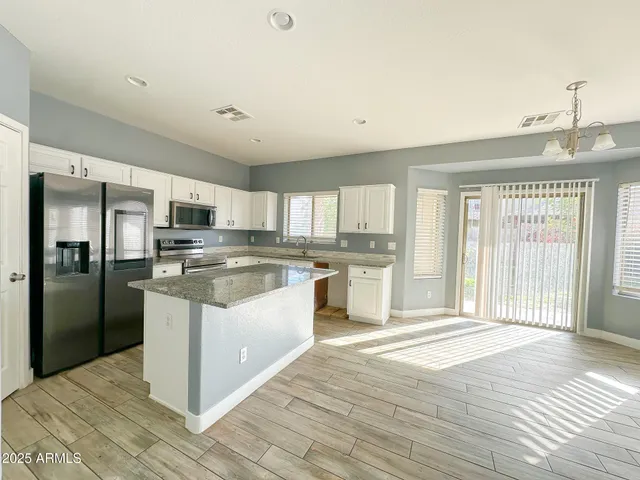a large kitchen with kitchen island a sink a center island and stainless steel appliances