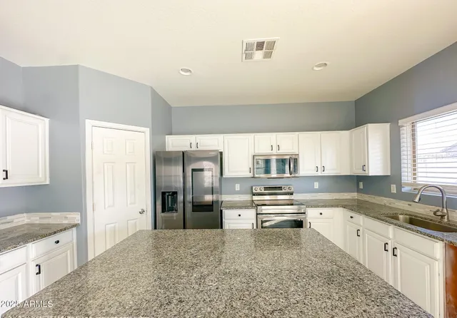 a kitchen with stainless steel appliances granite countertop a refrigerator sink and cabinets