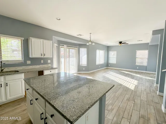a kitchen with granite countertop a sink and a wooden floor