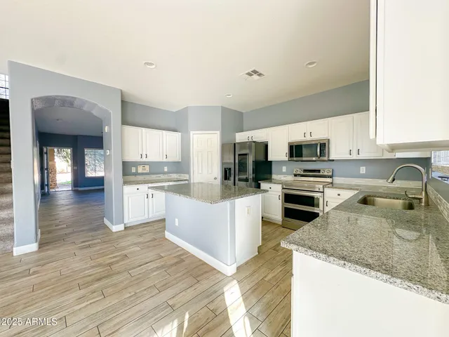 a kitchen with white cabinets and stainless steel appliances