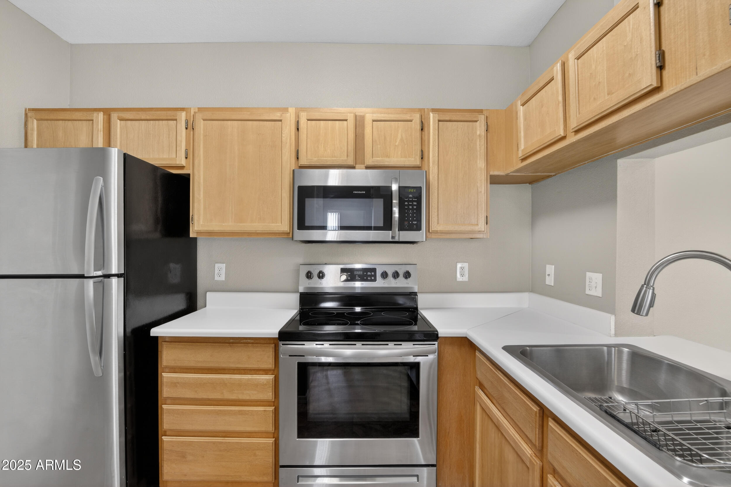 5401 East Van Buren Street, Unit 2022 Phoenix, AZ 85008 - Photo 5 of 37 a kitchen with granite countertop a refrigerator stove and microwave