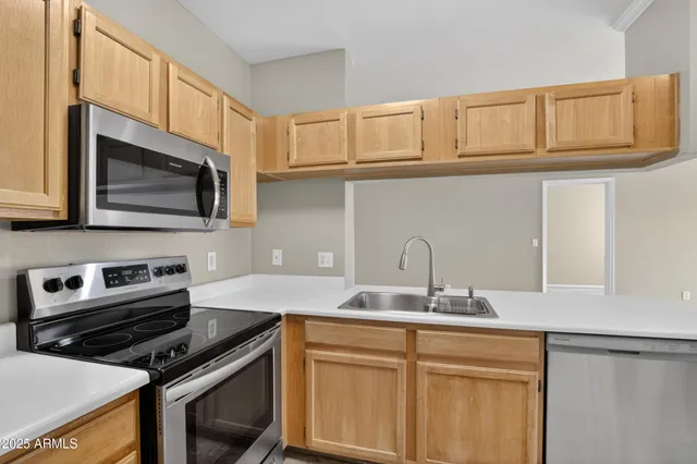 a kitchen with a refrigerator and a stove top oven