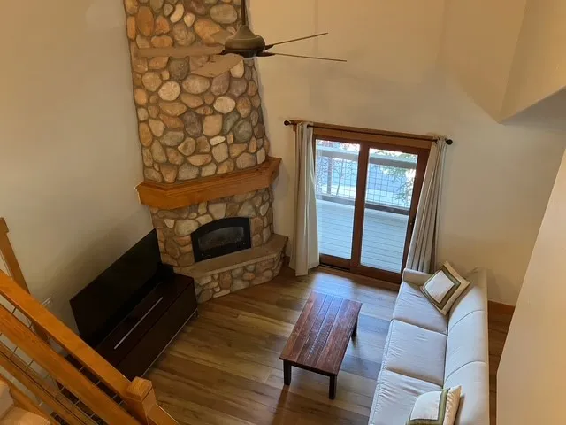 a living room with furniture a fireplace and a floor to ceiling window
